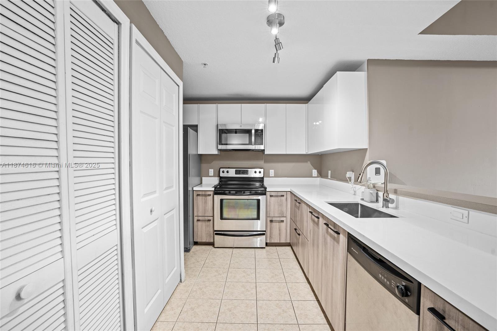5271 Southwest 8th Street, Unit 315 Miami, FL 33134 - Photo 6 of 26 a kitchen with a sink stove and cabinets