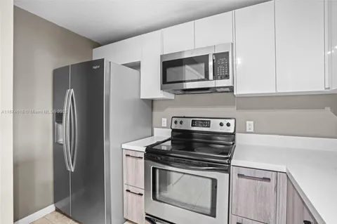 a kitchen with stainless steel appliances a stove a microwave and a hard wood floor