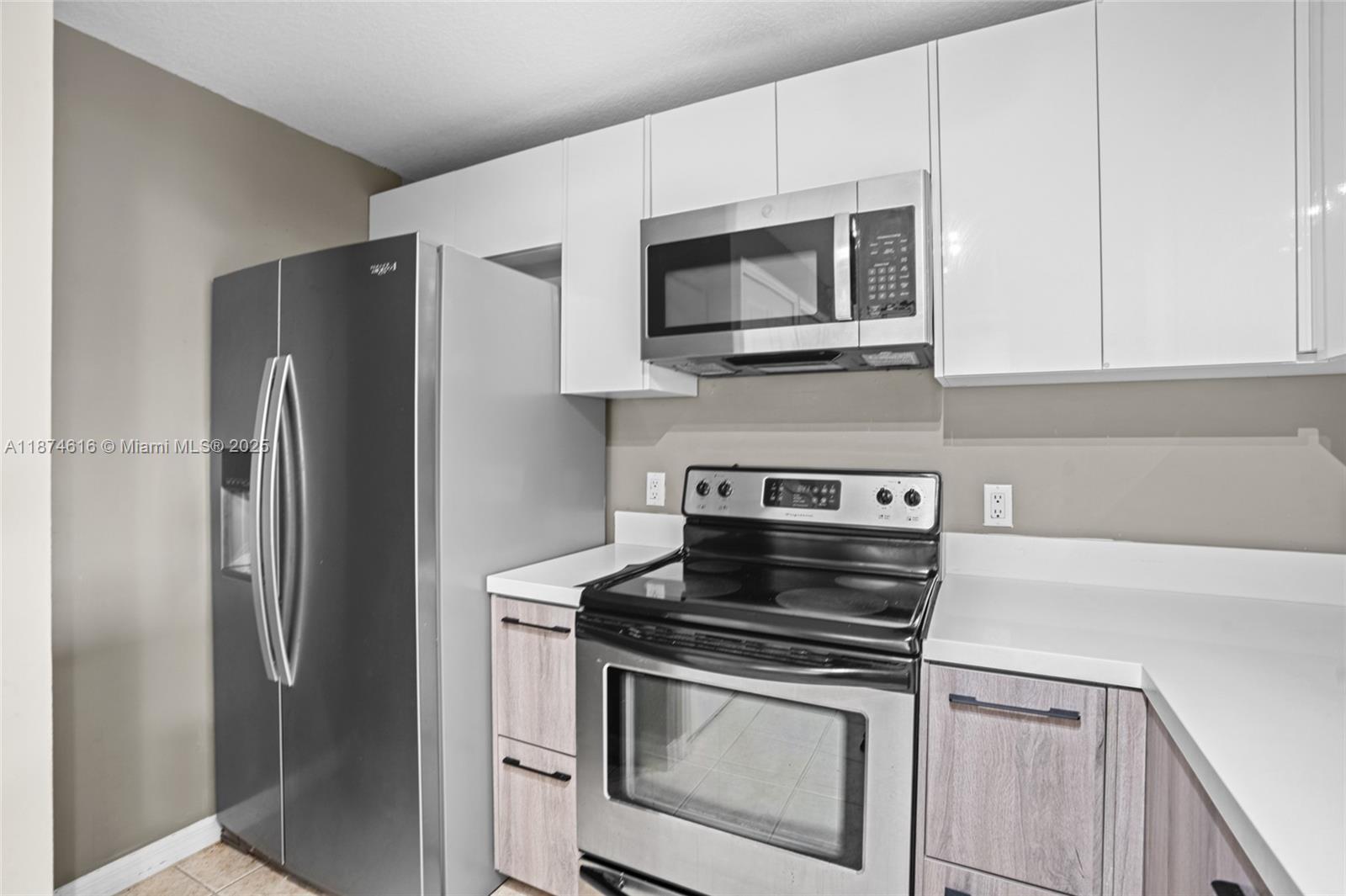 5271 Southwest 8th Street, Unit 315 Miami, FL 33134 - Photo 7 of 26 a kitchen with stainless steel appliances a stove a microwave and a hard wood floor