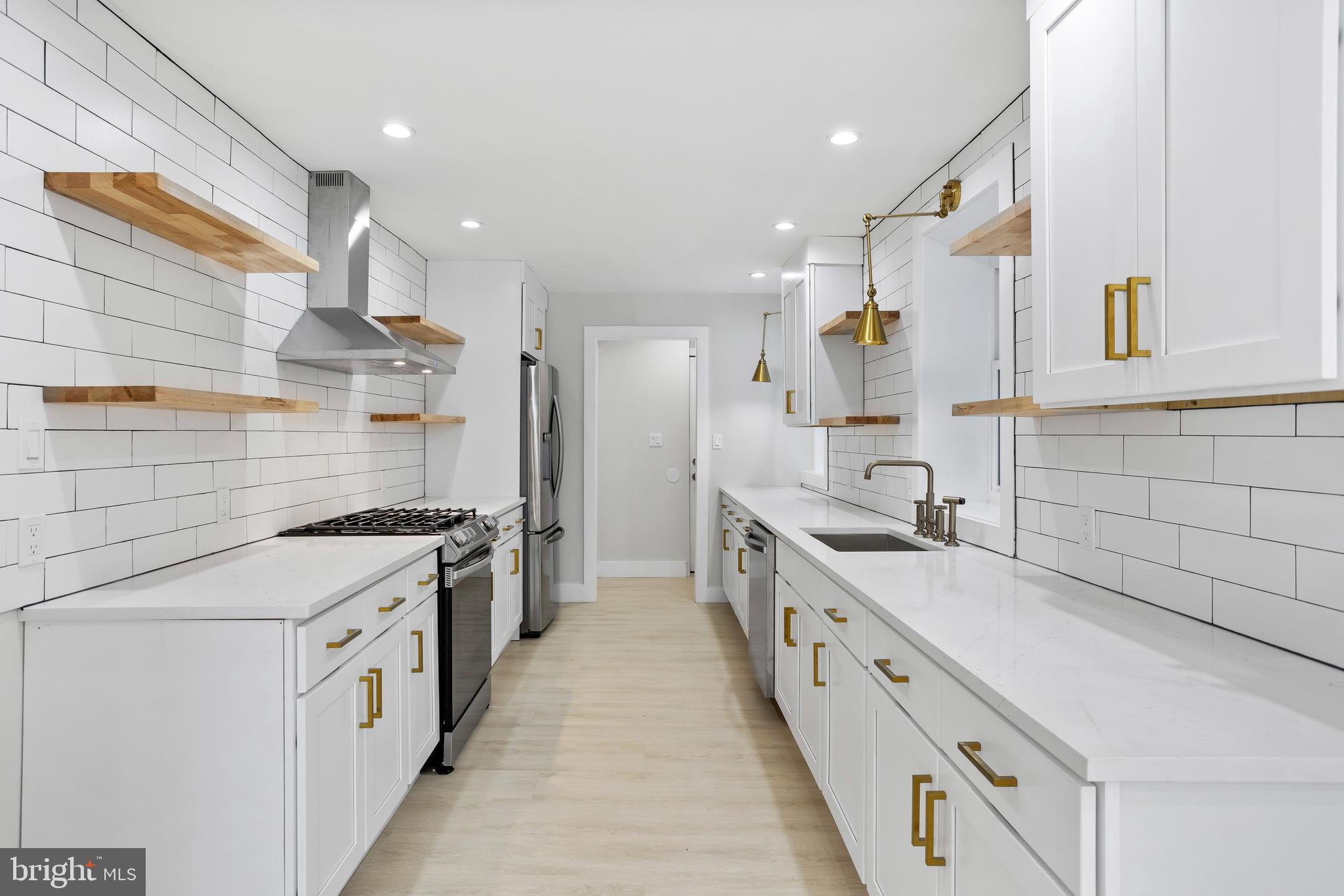 a large white kitchen with stainless steel appliances
