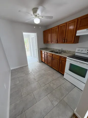 a kitchen with granite countertop stainless steel appliances white cabinets sink and dishwasher