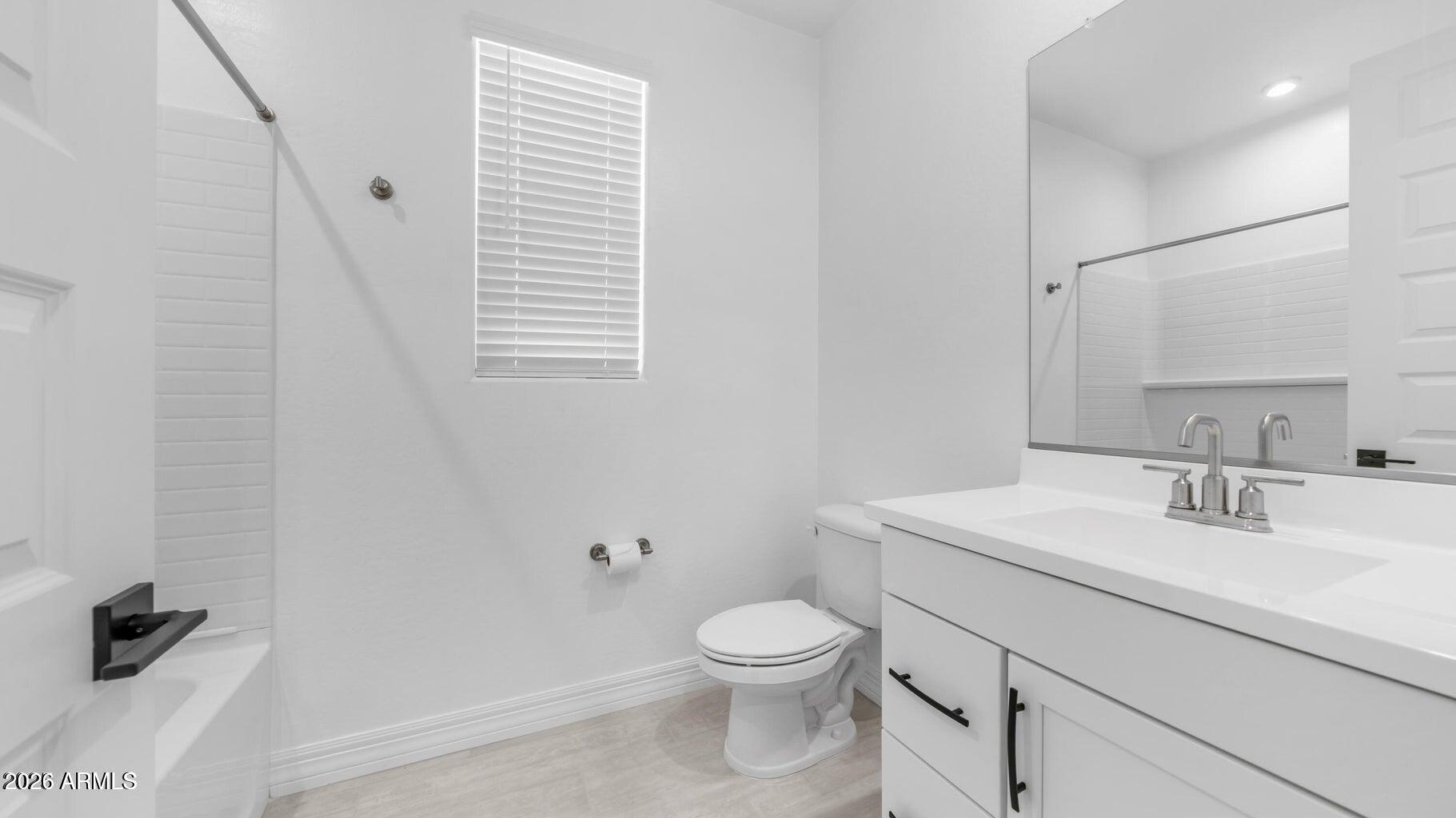 13359 West Eagle Feather Road Peoria, AZ 85383 - Photo 6 of 43 a bathroom with a toilet sink and mirror