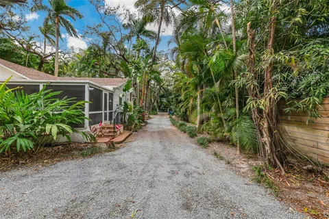 a view of a backyard with potted plants and large tree