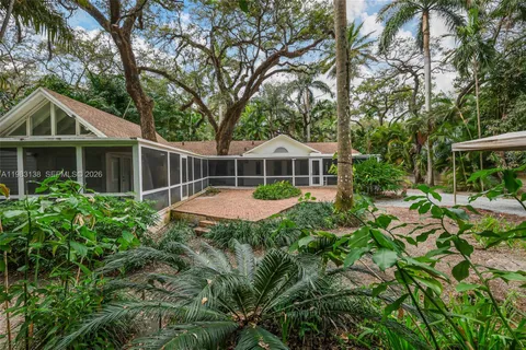 a front view of house with yard and trees around