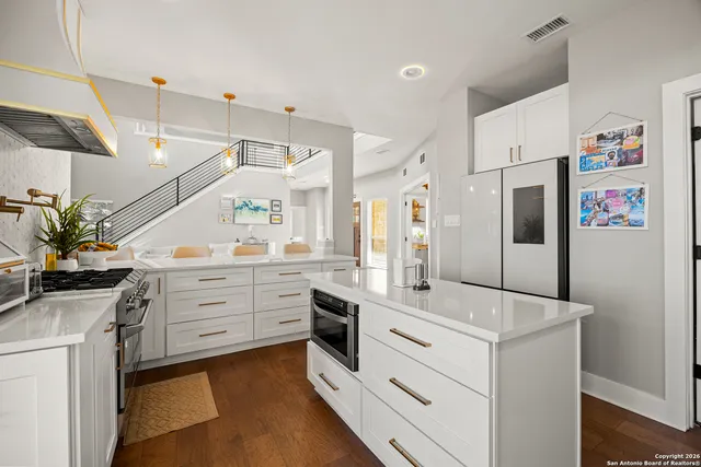 a kitchen with white cabinets and stainless steel appliances