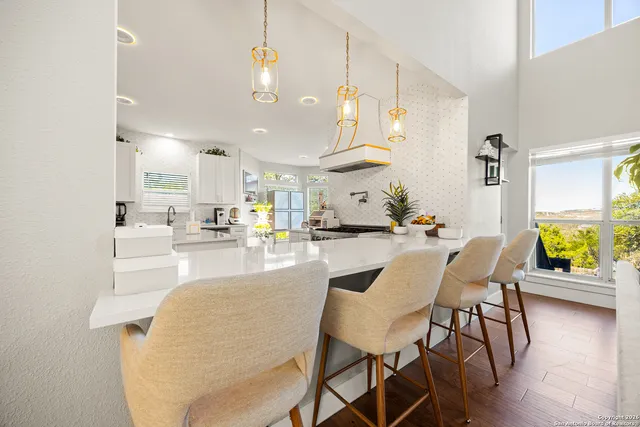 a kitchen with a sink a refrigerator and white cabinets