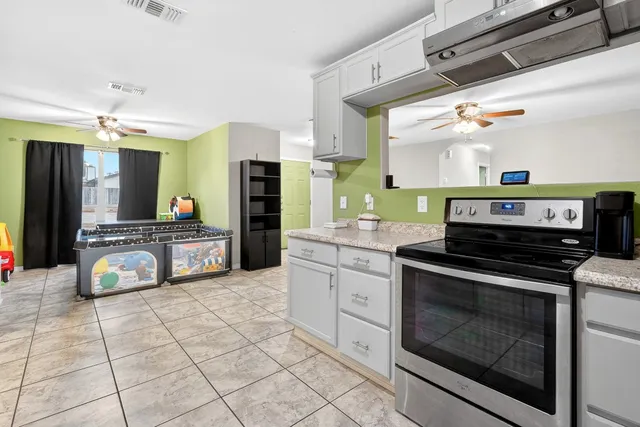 a kitchen with stainless steel appliances kitchen island granite countertop a stove a sink and a microwave