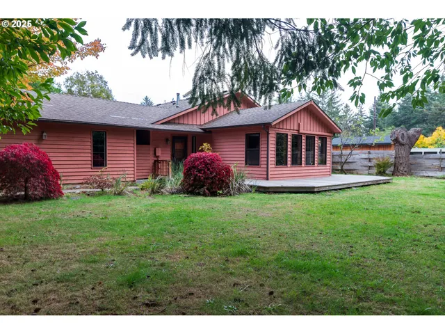 a front view of a house with a garden and trees