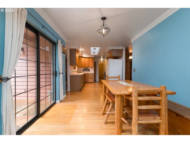 a view of a dining room with furniture a chandelier and wooden floor