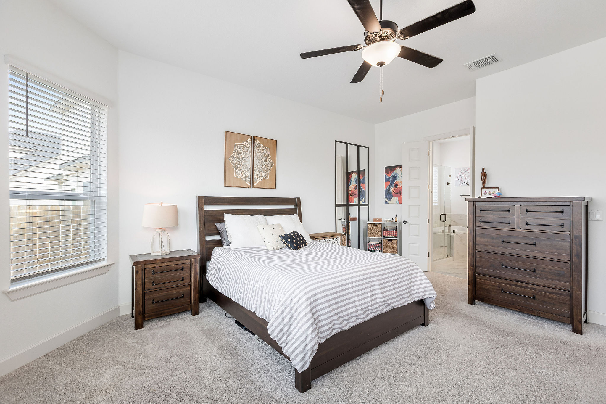 4605 Sea Salt Drive Austin, TX 78747 - Photo 24 of 40 a bedroom with a bed a dresser and a chandelier