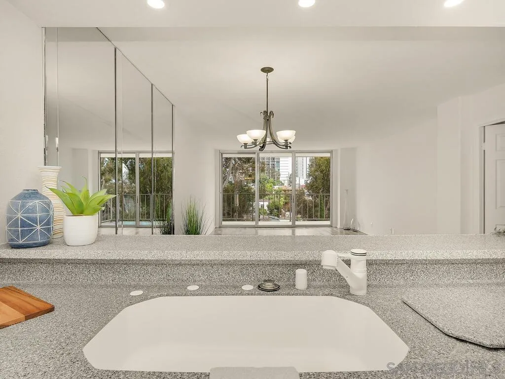 3634 7th Avenue, Unit 4B San Diego, CA 92103 - Photo 18 of 50 a bathroom with a granite countertop sink a large mirror and a window