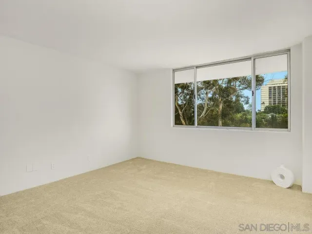 a bedroom with a bed and painting on the wall