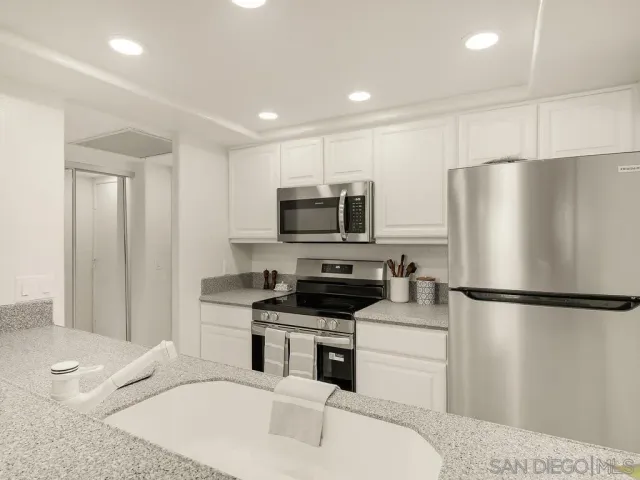 a living room with couch a flat screen tv and a large window