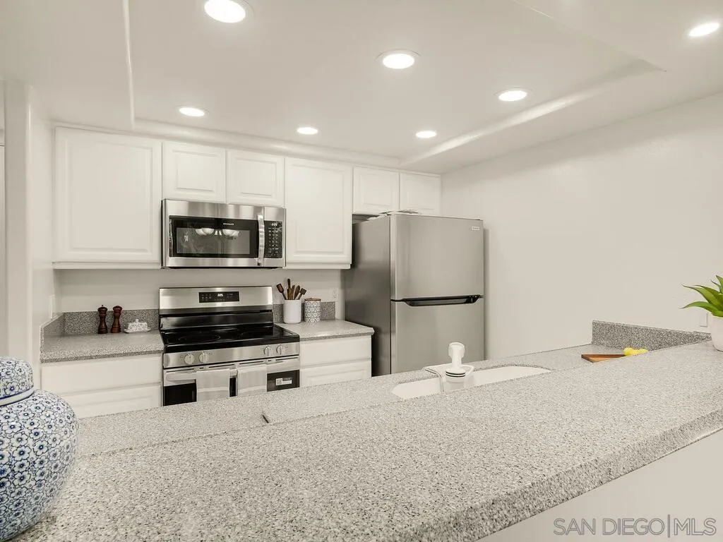 3634 7th Avenue, Unit 4B San Diego, CA 92103 - Photo 9 of 50 a kitchen with stainless steel appliances a stove a sink a microwave a refrigerator and cabinets