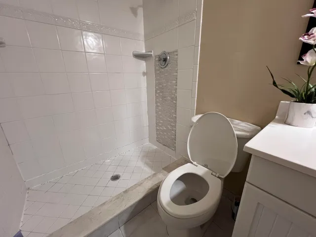 a view of an empty room with wooden floor and a ceiling fan