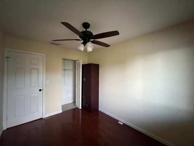 an empty room with a window and a ceiling fan