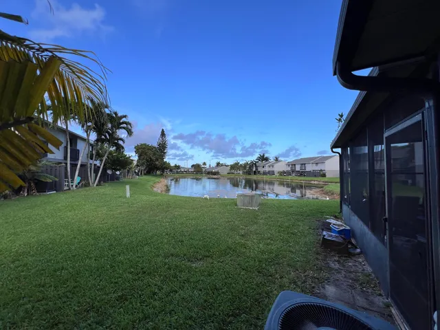 a view of a house with a small yard and a palm tree