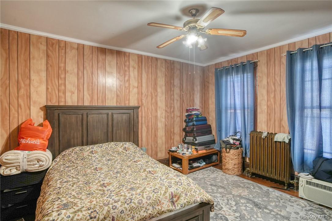 32 Balding Avenue Poughkeepsie, NY 12601 - Photo 16 of 39 Bedroom with ceiling fan, crown molding, radiator heating unit, and wooden walls
