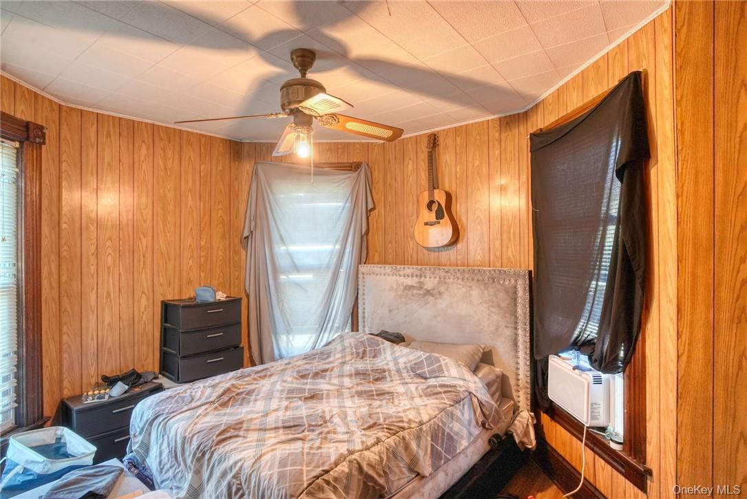 32 Balding Avenue Poughkeepsie, NY 12601 - Photo 17 of 39 Bedroom featuring cooling unit, wooden walls, and ceiling fan