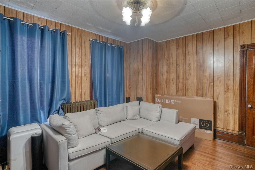 32 Balding Avenue Poughkeepsie, NY 12601 - Photo 24 of 39 Living room with wood walls, hardwood / wood-style floors, and ceiling fan