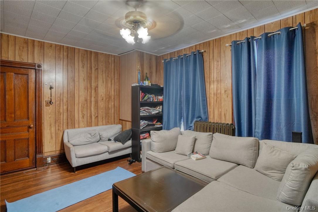 32 Balding Avenue Poughkeepsie, NY 12601 - Photo 25 of 39 Living room featuring hardwood / wood-style floors, wooden walls, and ceiling fan
