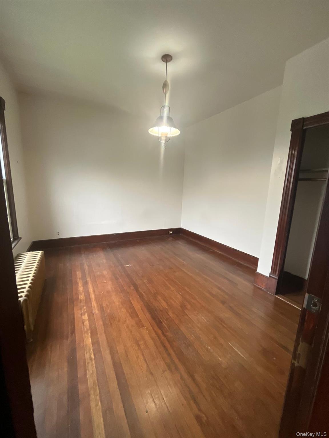 32 Balding Avenue Poughkeepsie, NY 12601 - Photo 35 of 39 Unfurnished bedroom featuring dark wood-style floors and radiator heating unit