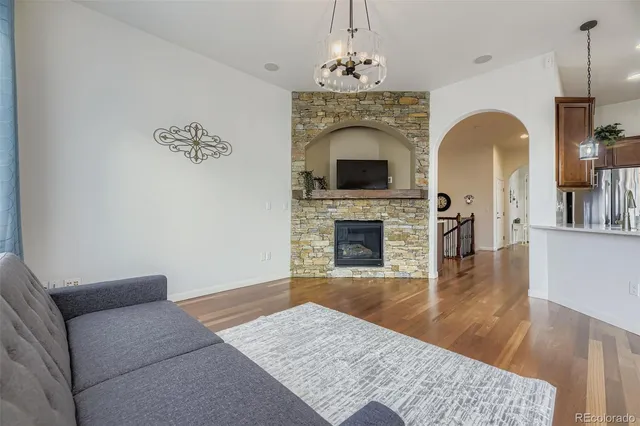 a living room with furniture a fireplace and wooden floor