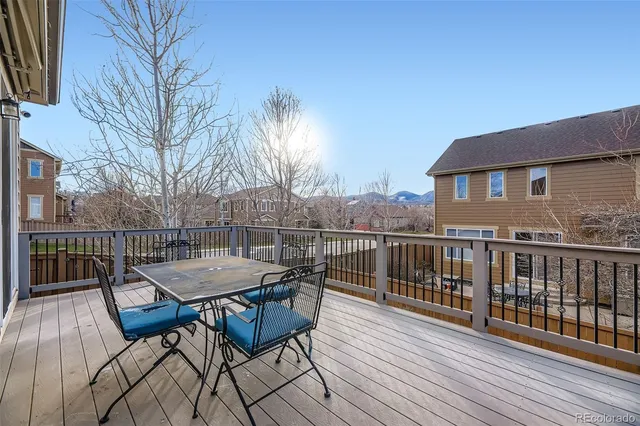 a view of a roof deck with table and chairs and wooden floor