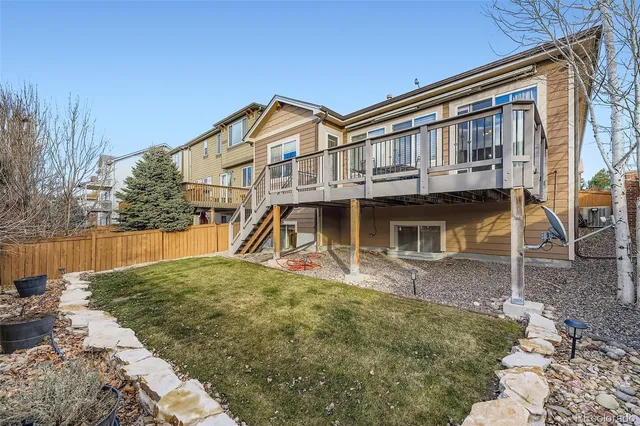 a view of a white house with large windows next to a yard