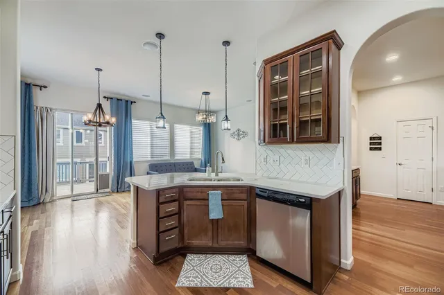 a kitchen with a sink stove and wooden floor