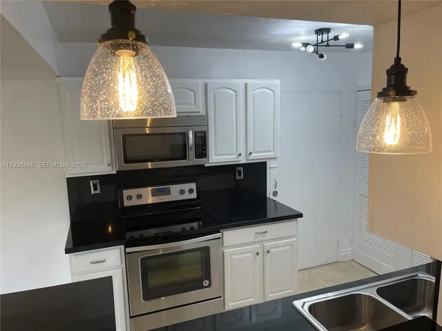 a kitchen with a stove microwave and a sink