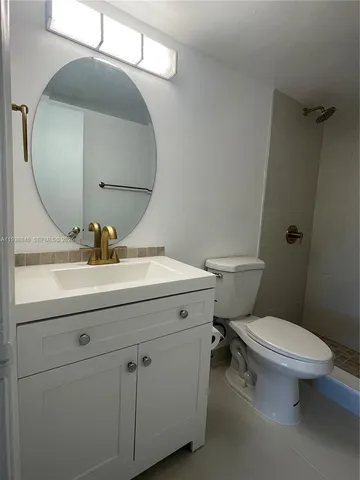 a bathroom with a sink mirror and toilet