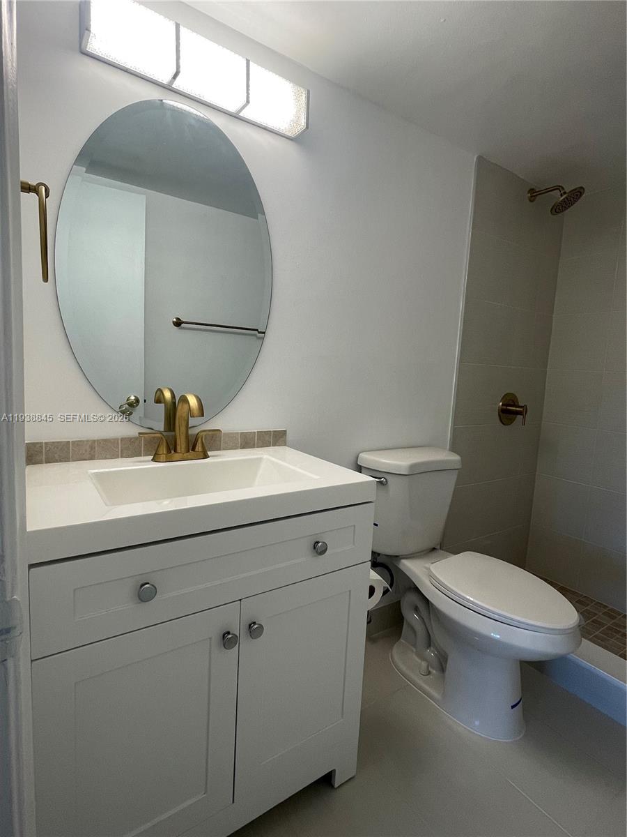 7483 Southwest 82nd Street, Unit A101 Miami, FL 33143 - Photo 21 of 39 a bathroom with a sink mirror and toilet