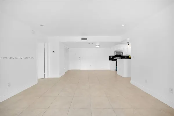 a view of a kitchen with refrigerator and white cabinets