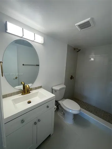 a bathroom with a sink mirror and toilet
