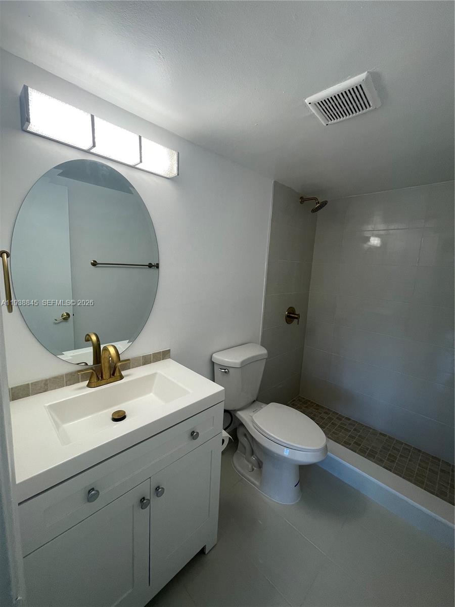 7483 Southwest 82nd Street, Unit A101 Miami, FL 33143 - Photo 23 of 39 a bathroom with a sink mirror and toilet