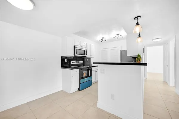 a kitchen with stainless steel appliances granite countertop a sink a stove and refrigerator
