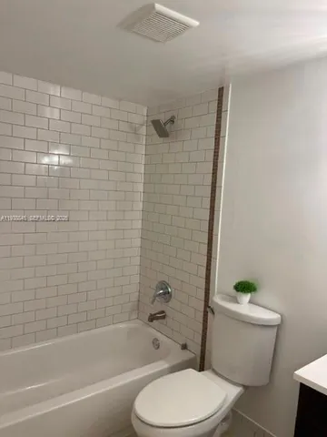 a white toilet and tub sitting next to a bathroom sink