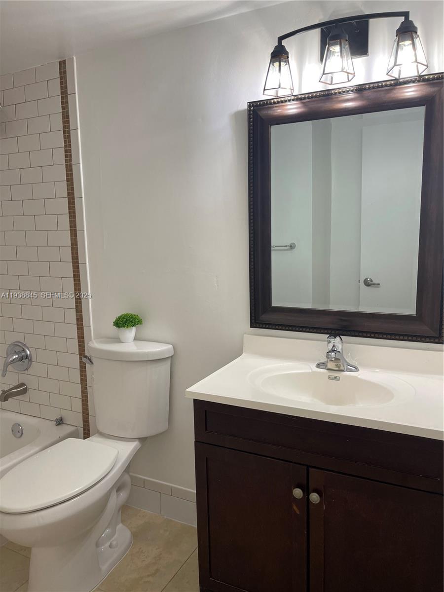 7483 Southwest 82nd Street, Unit A101 Miami, FL 33143 - Photo 30 of 39 a bathroom with a sink a toilet and mirror