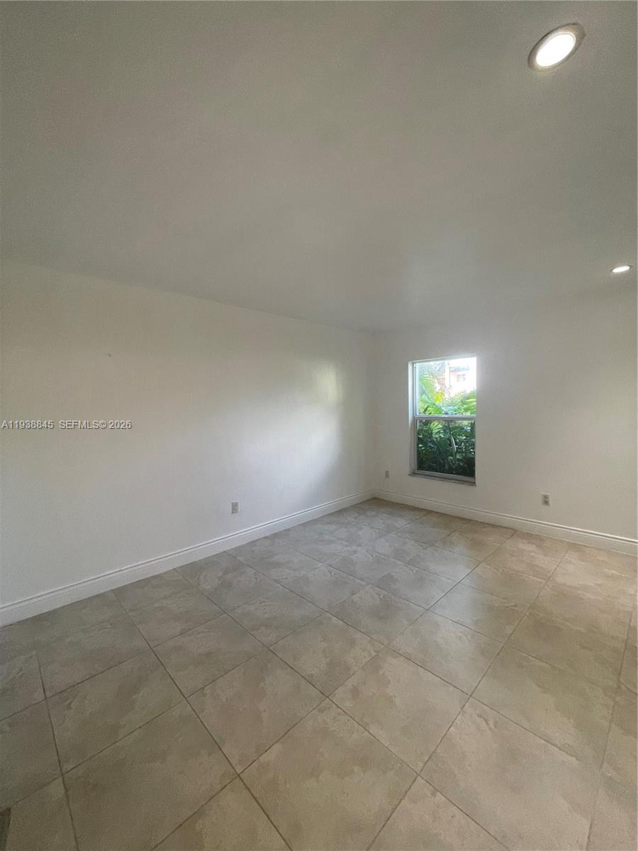 7483 Southwest 82nd Street, Unit A101 Miami, FL 33143 - Photo 32 of 39 an empty room with windows and entrance
