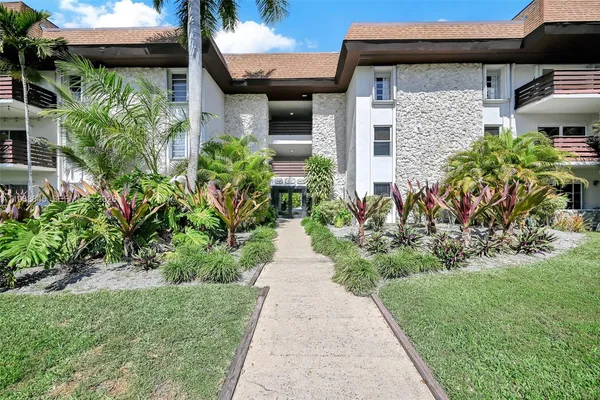 a front view of a house with a yard and potted plants
