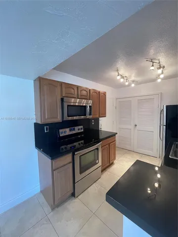 a kitchen with stainless steel appliances a microwave a stove and a refrigerator
