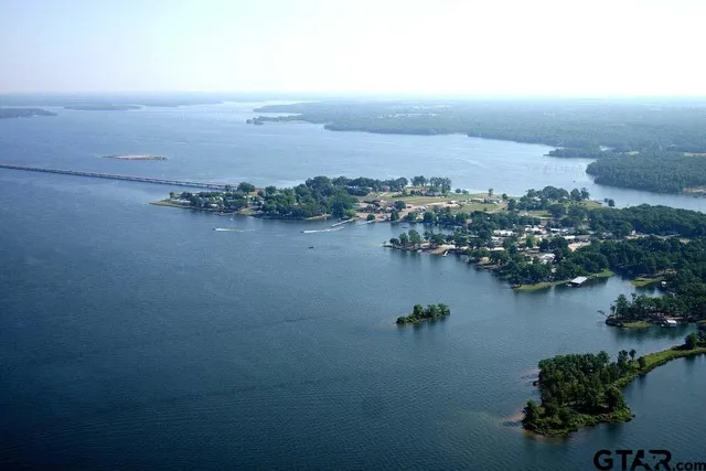 an aerial view of ocean and residential houses with outdoor space