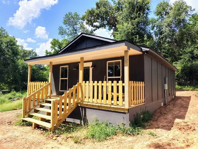 a view of a house with wooden deck and backyard