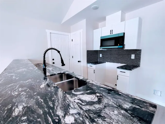 a kitchen with sink a stove and cabinets