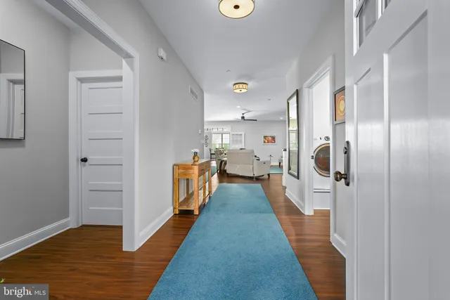 a view of a hallway with wooden floor and staircase