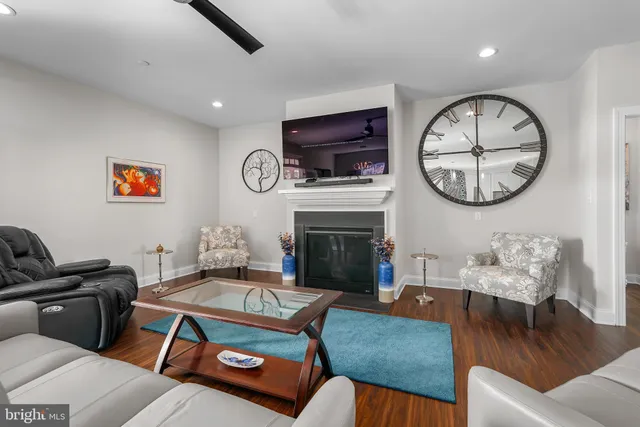 a living room with furniture a clock and a fireplace
