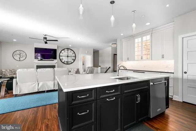 a kitchen with a sink dishwasher and a clock on the wall