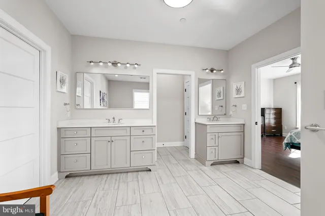 a spacious bathroom with a double vanity sink a mirror and a bathtub