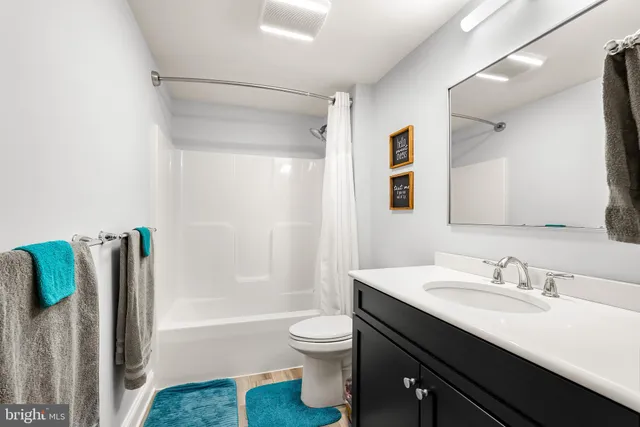 a bathroom with a double vanity sink toilet and shower